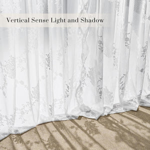 White sheer curtains with delicate floral embroidery, sunlight creating shadows on the floor.
