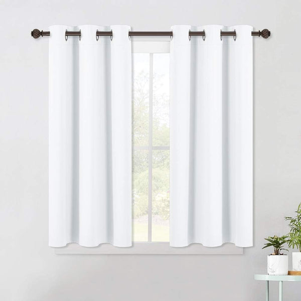 Two white fabric grommet top curtains hanging on a dark bronze rod over a window.