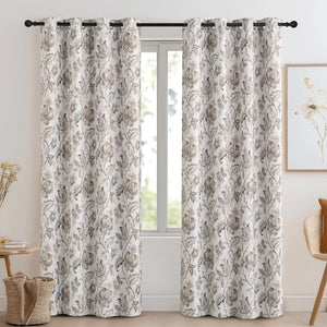 White floral paisley pattern curtains with black grommet tops, hanging in a bright living room window.