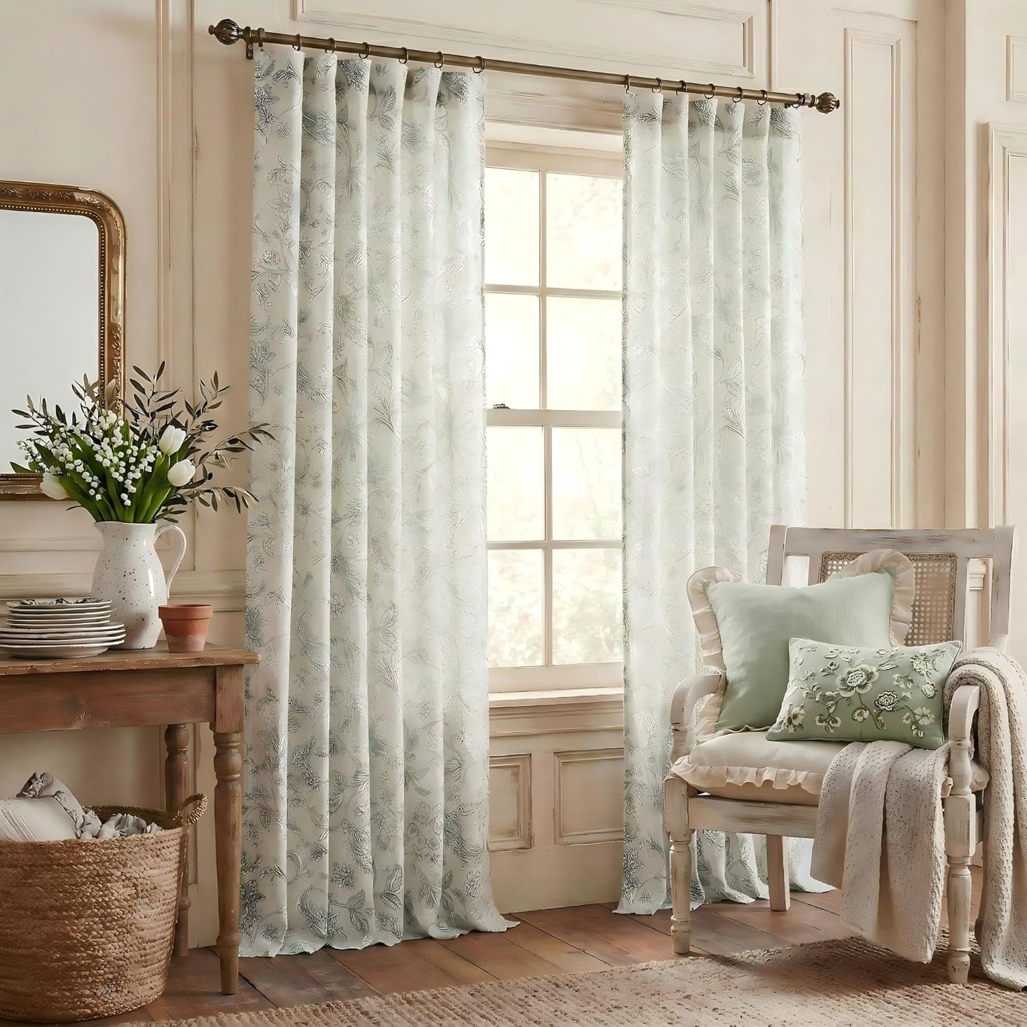 Pair of white light-filtering curtains with a delicate blue-grey floral pattern, hanging on a bronze rod.