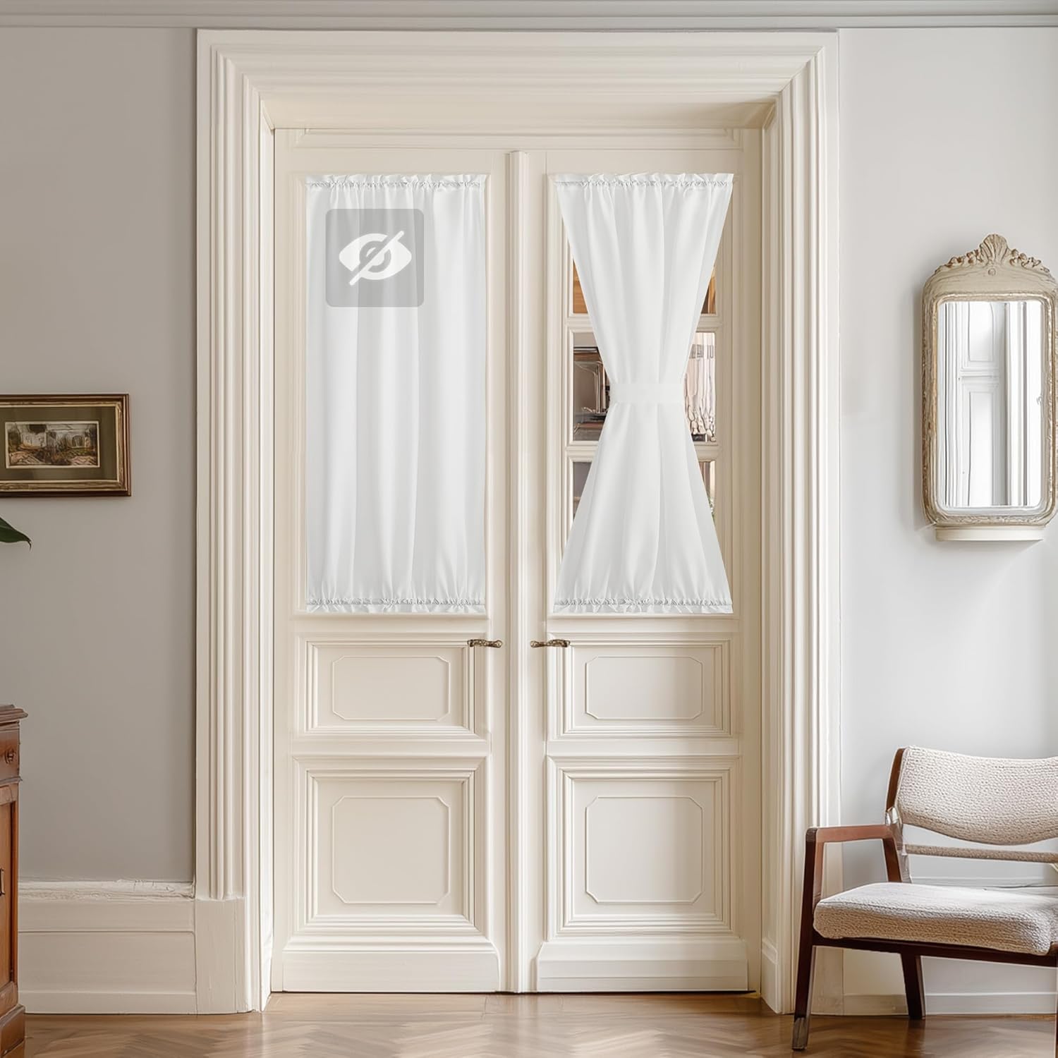 White privacy curtains with rod pocket top covering the glass panes of a French door, one tied in the middle.