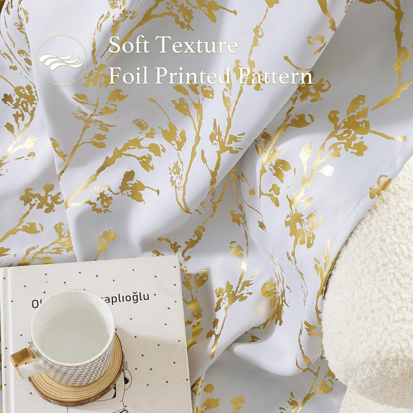 Soft white curtain with elegant gold foil printed botanical pattern. A patterned mug and book are nearby.