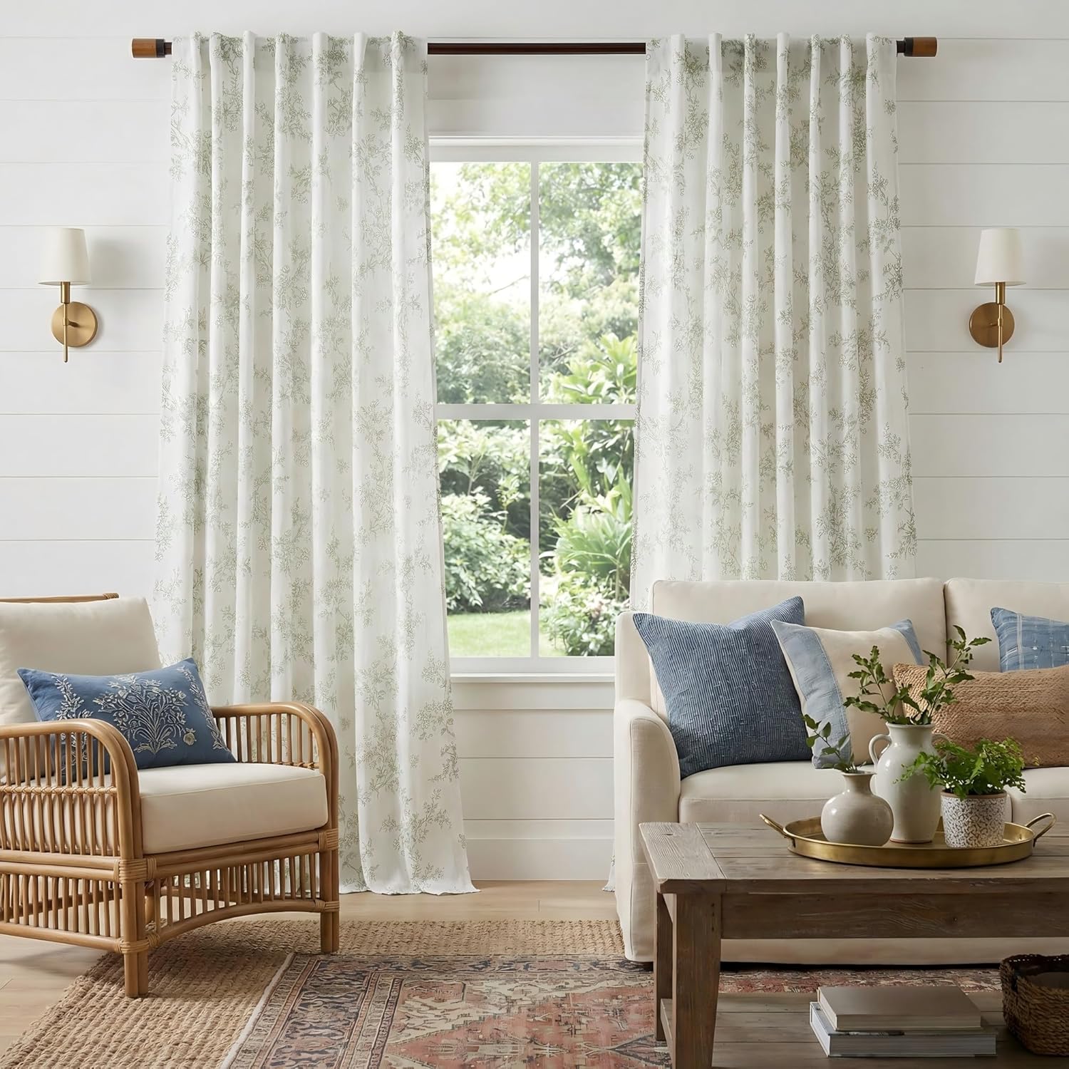 White curtains with delicate light green botanical pattern and pleated top, enhancing a bright farmhouse living room.