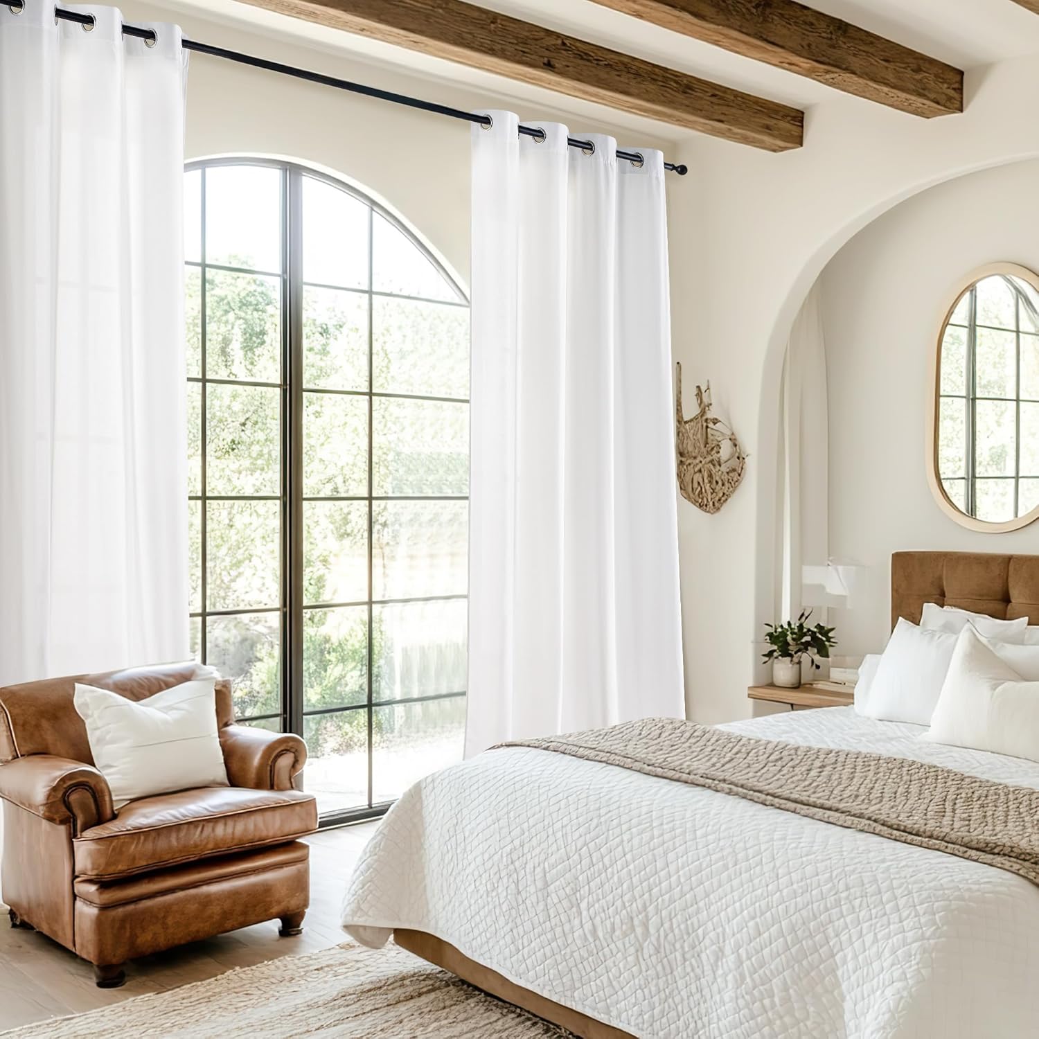 White grommet top curtains on a black rod, filtering light in a bright, modern bedroom.