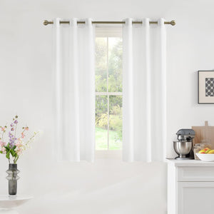 White grommet top semi-sheer curtains on a bronze rod, filtering light in a modern kitchen.