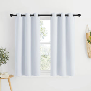 White grommet top short curtains hanging on a black rod over a window. Smooth fabric provides privacy.