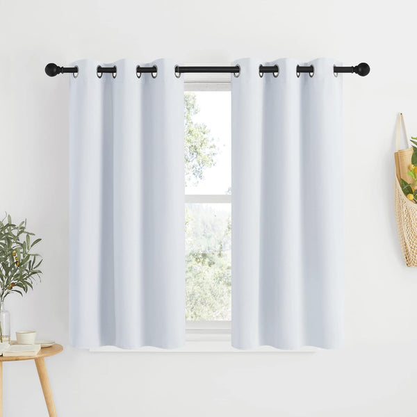 White grommet top short curtains hanging on a black rod over a window. Smooth fabric provides privacy.