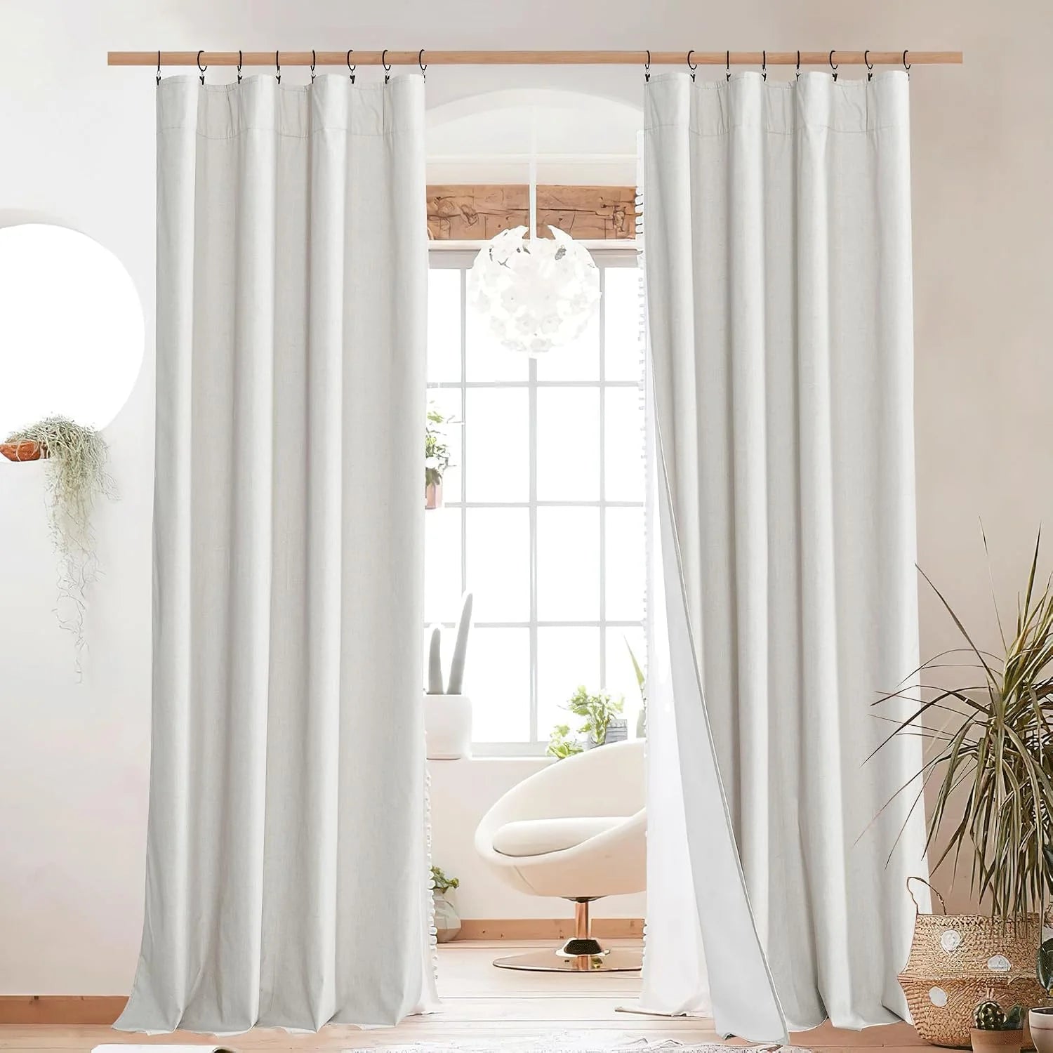 Soft white linen curtains on a wooden rod in a bright modern room