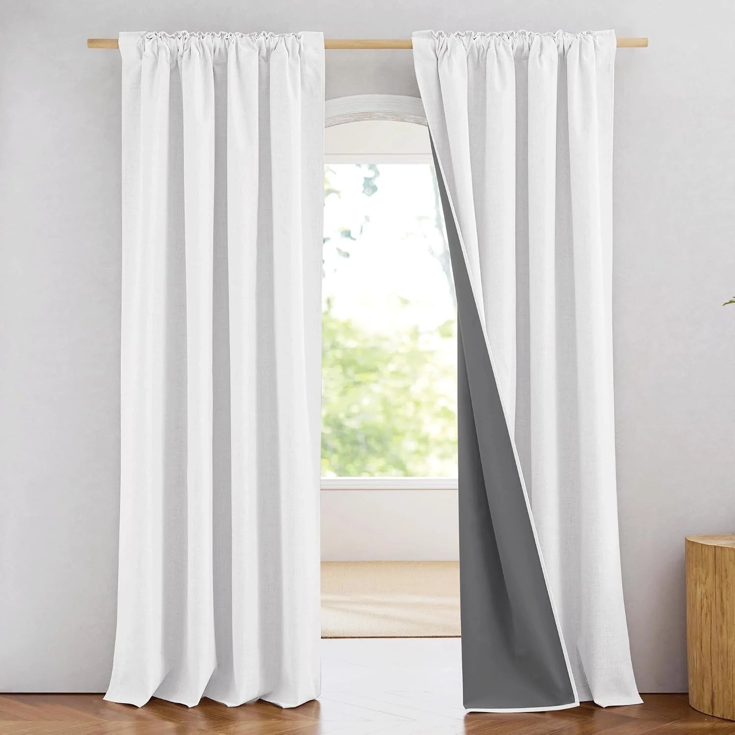White linen-look blackout curtains with rod pocket top on a light wood curtain rod