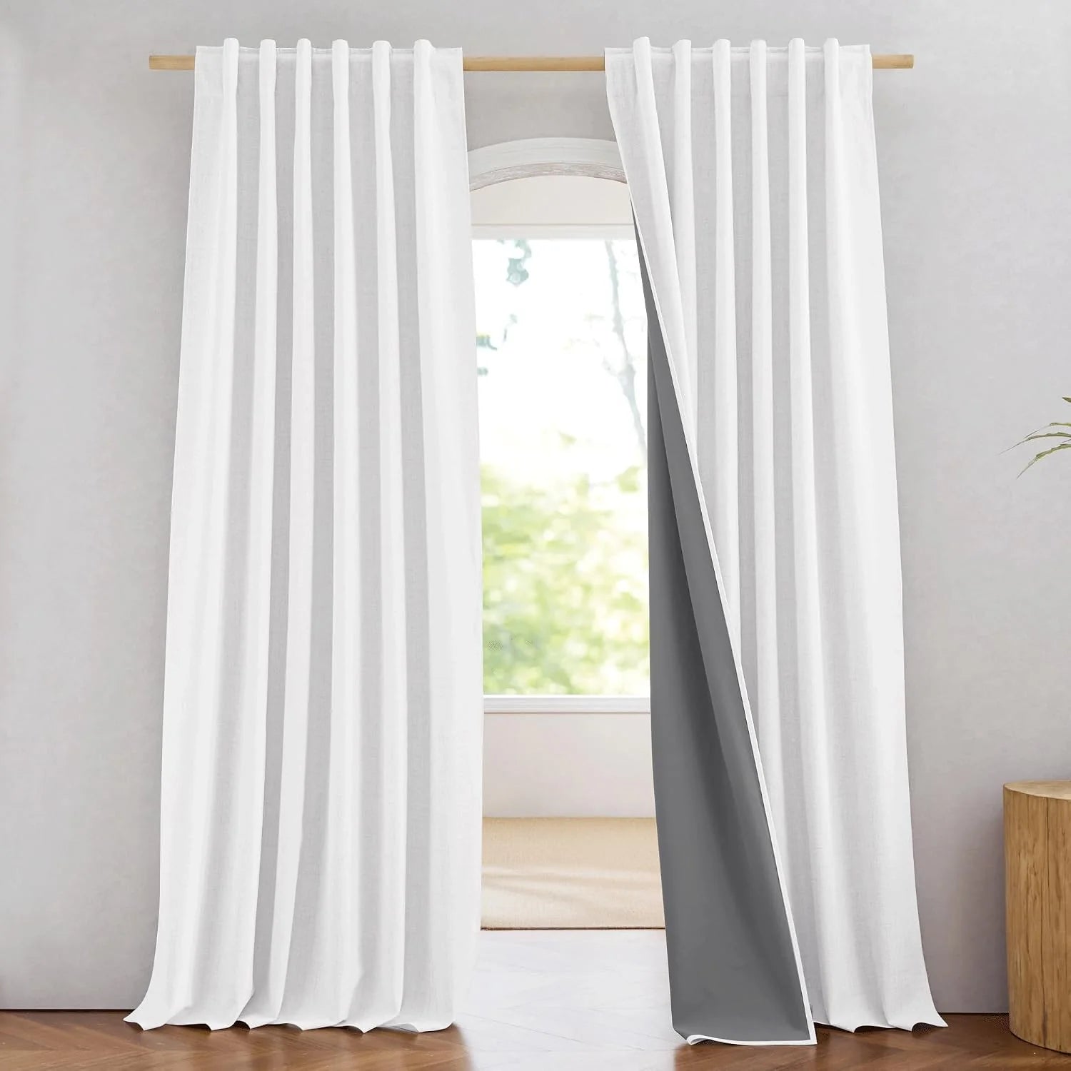 White linen-look curtains with rod pocket pleats hanging on a wooden curtain rod