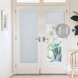 White magnetic roman shades on glass french doors, one extended, another rolled up.