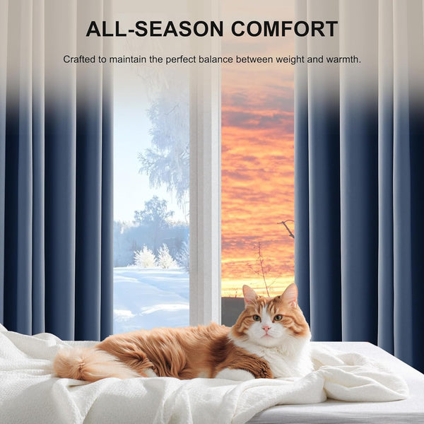 White to navy ombre thermal blackout curtains frame a window, a fluffy cat resting comfortably on a white bed.