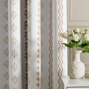 White curtains with distinct vertical rust and brown patterns: floral, geometric, and wavy designs.