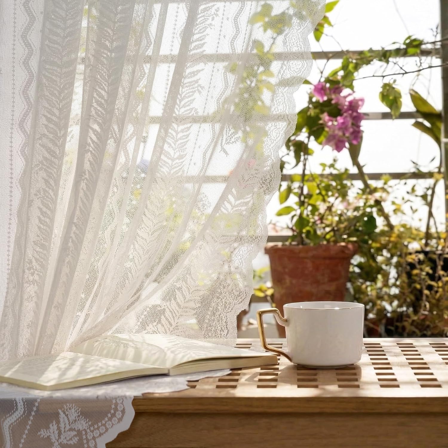 White patterned sheer curtains with delicate lace design, filtering sunlight in a cozy window setting.