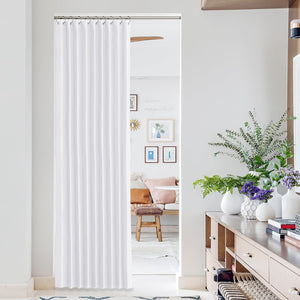 White pleated fabric room divider curtain covering a doorway, hung from a silver rod with hooks.