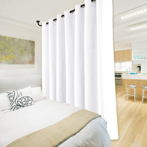 White privacy room divider curtain with black grommet top separating a modern bedroom from a kitchen.