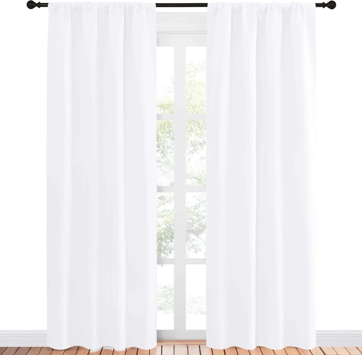 Pair of bright white rod pocket curtains on a black rod in a sunny room