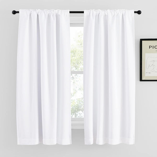 Pair of white opaque rod pocket curtains hanging from a black rod over a window.