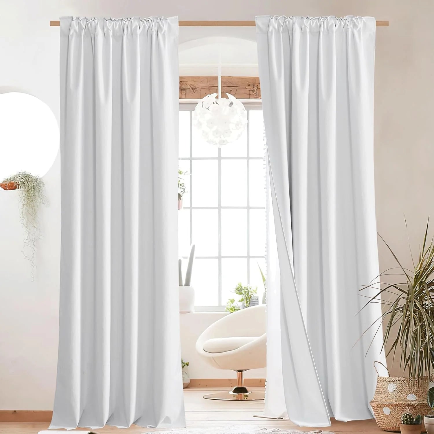 White rod pocket curtains hanging on a wood pole in a bright modern room