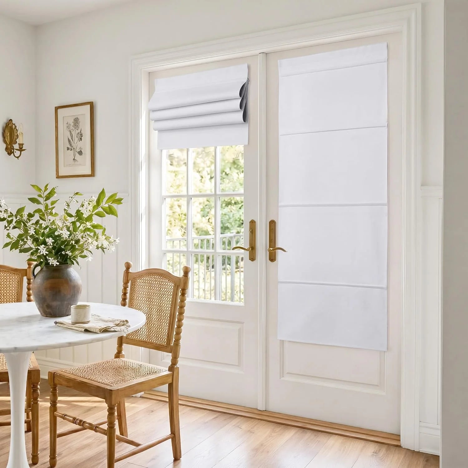 White flat Roman shades on French patio doors in a bright dining room with cane chairs.