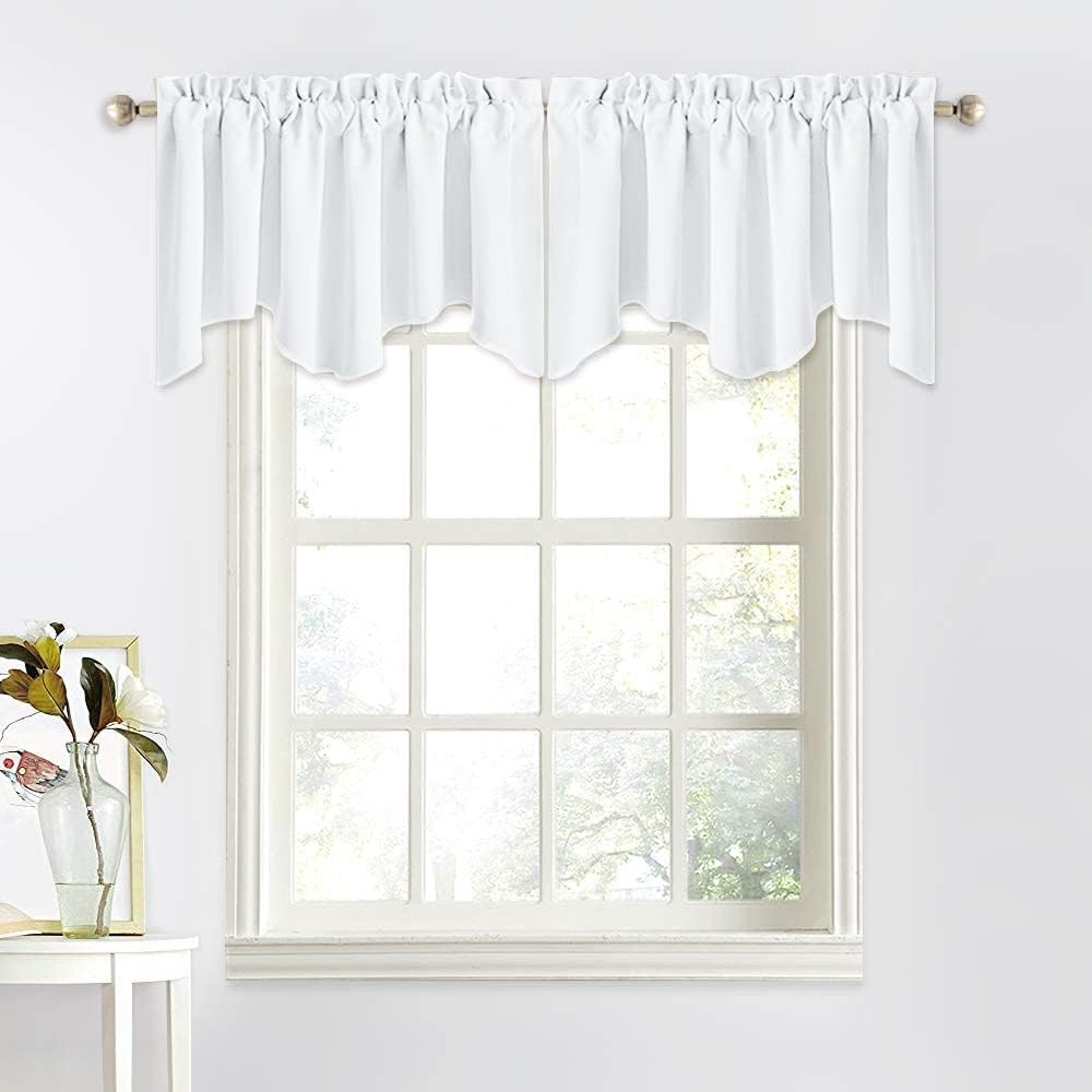 White fabric window valance with gathered rod pocket and scalloped bottom edge, on a brushed nickel rod.