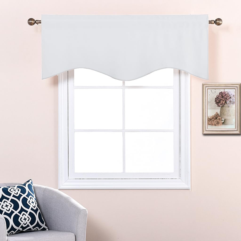 Solid white window valance with a stylish wavy bottom edge, hung on a bronze rod above a window.