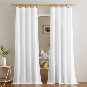 Two white semi-sheer drapes, hung with wooden clip rings on a natural wood rod, framing an arched opening.