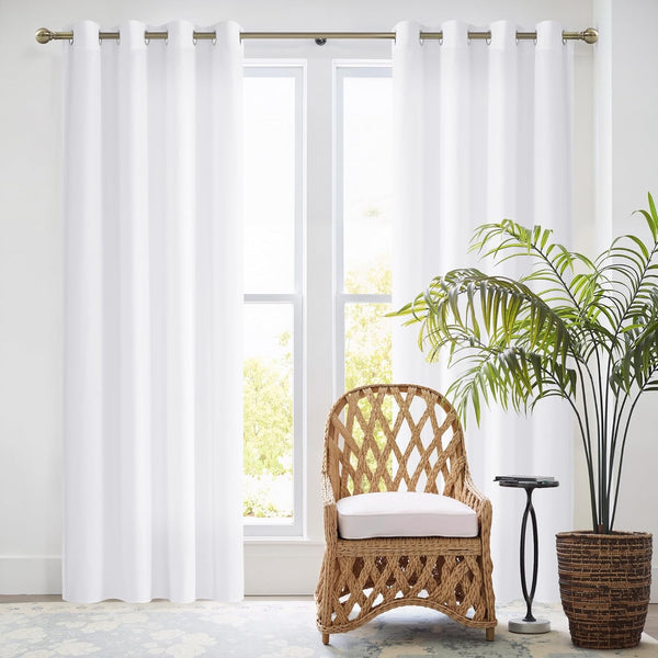 Pure white semi-sheer grommet curtains on a decorative bronze rod, brightening a modern living space.