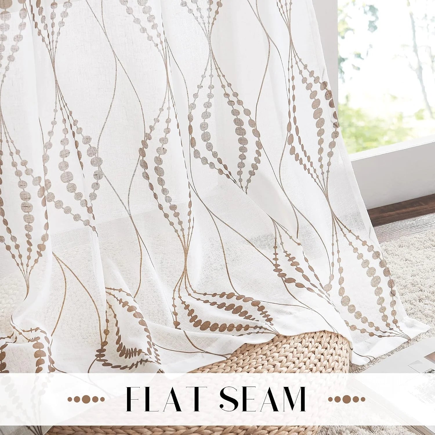 White sheer curtain with taupe embroidered wave pattern hanging by a bright window