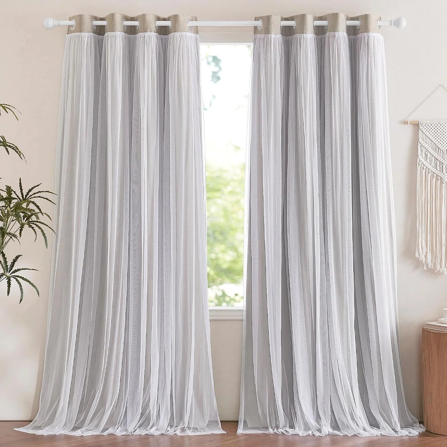 White sheer grommet curtains hanging in a bright neutral room by a window