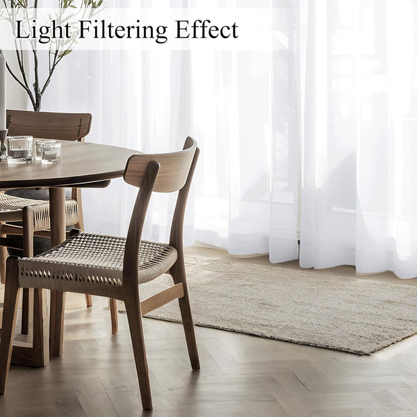 White sheer light filtering curtains beautifully diffuse natural light in a modern dining room.