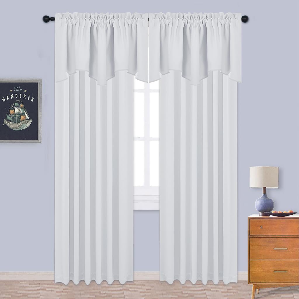 White sheer rod pocket curtains with attached valance, hanging on a dark rod over a window.
