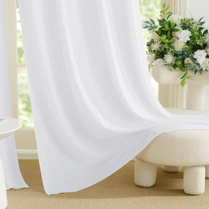 White sheer light filtering curtains gracefully draped over a cream bouclé stool.