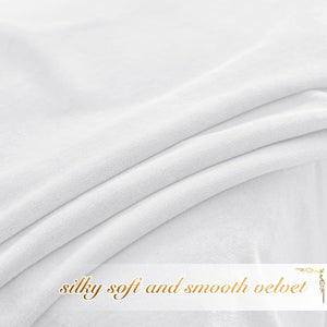 Close-up of white, silky soft velvet fabric with gentle folds, showcasing its smooth texture.