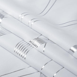White woven fabric with shimmering silver metallic stripes. The folds create an intersecting geometric pattern.