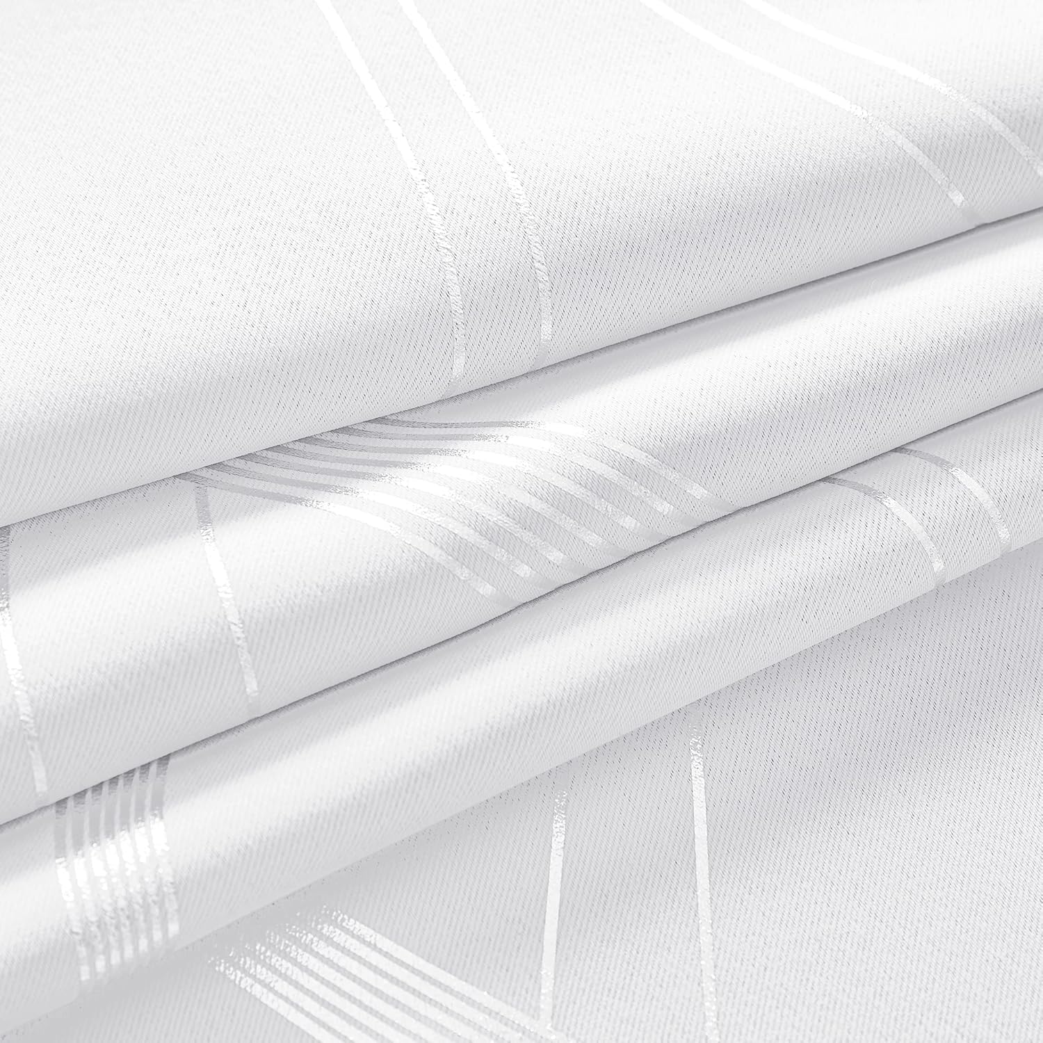 White woven fabric with shiny silver geometric stripes, softly folded to highlight its reflective pattern.