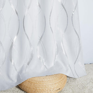 Elegant white fabric curtain featuring a shimmering metallic silver wavy line pattern, draped over a wicker stool.