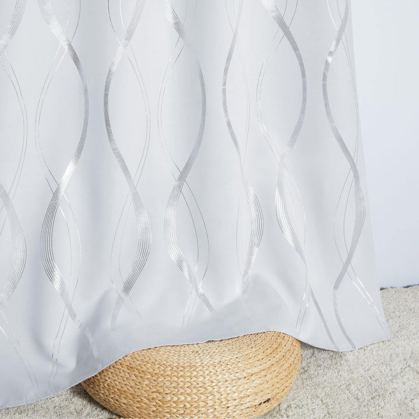 Elegant white fabric curtain featuring a shimmering metallic silver wavy line pattern, draped over a wicker stool.