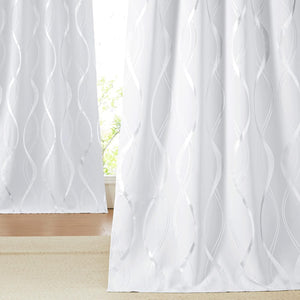 Elegant white curtains featuring a shimmering silver wavy line pattern, subtly filtering window light.