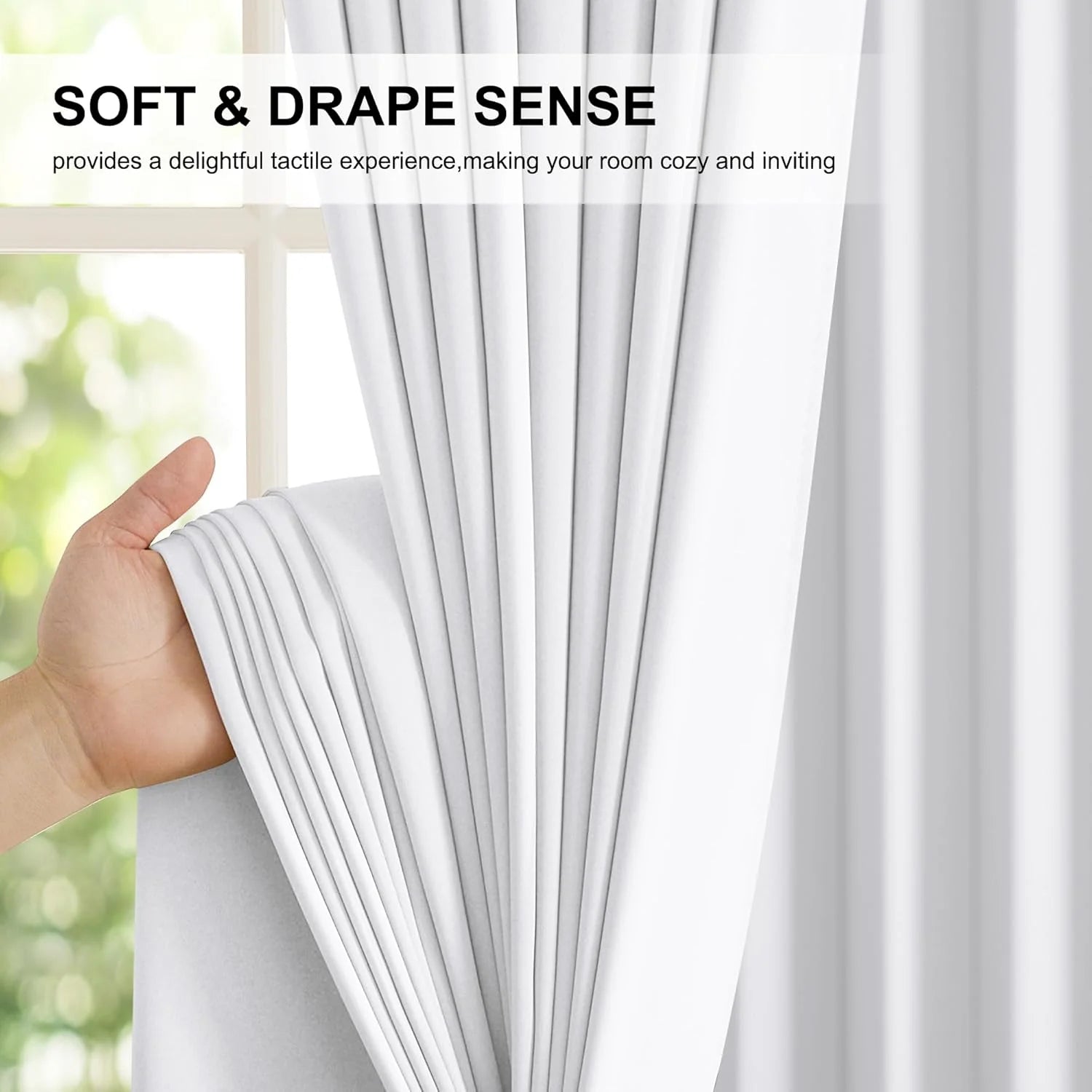Hand holding soft white curtain fabric with elegant drape beside a bright window