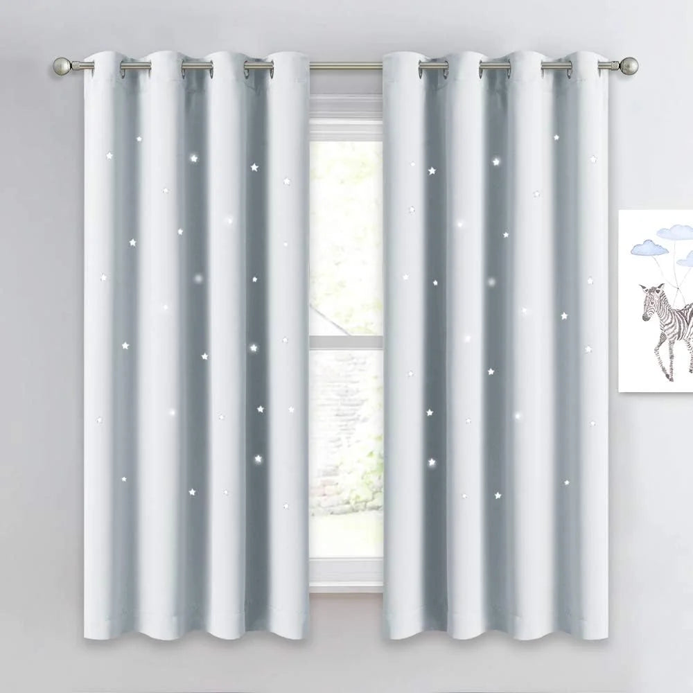 White blackout curtains with glowing star cutouts and silver grommets on a window