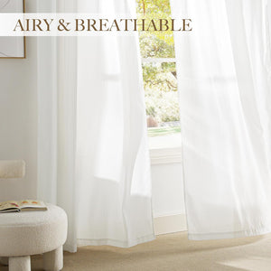 White sheer curtains with fine vertical stripes hanging in front of a window, allowing light to filter into the room.