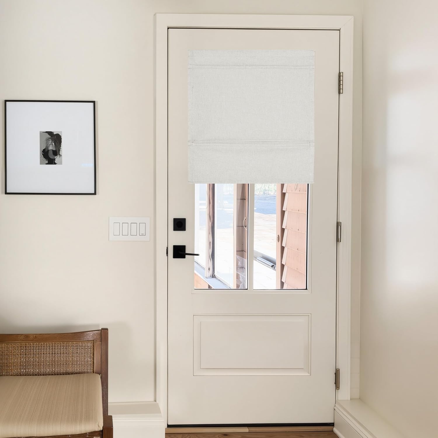 Off-white textured roman door blind with flat folds covering the upper half of a glass paneled door.