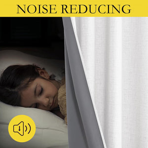Child sleeps peacefully in darkened room behind light grey textured noise reducing curtain with dark lining.