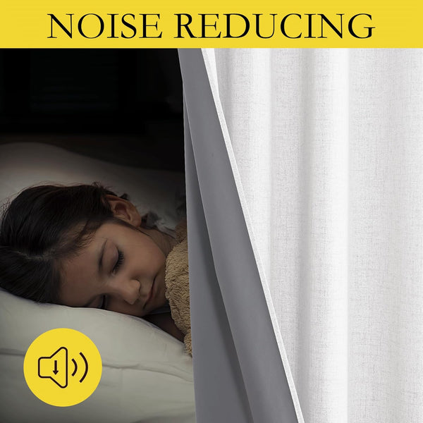 Child sleeps peacefully in darkened room behind light grey textured noise reducing curtain with dark lining.