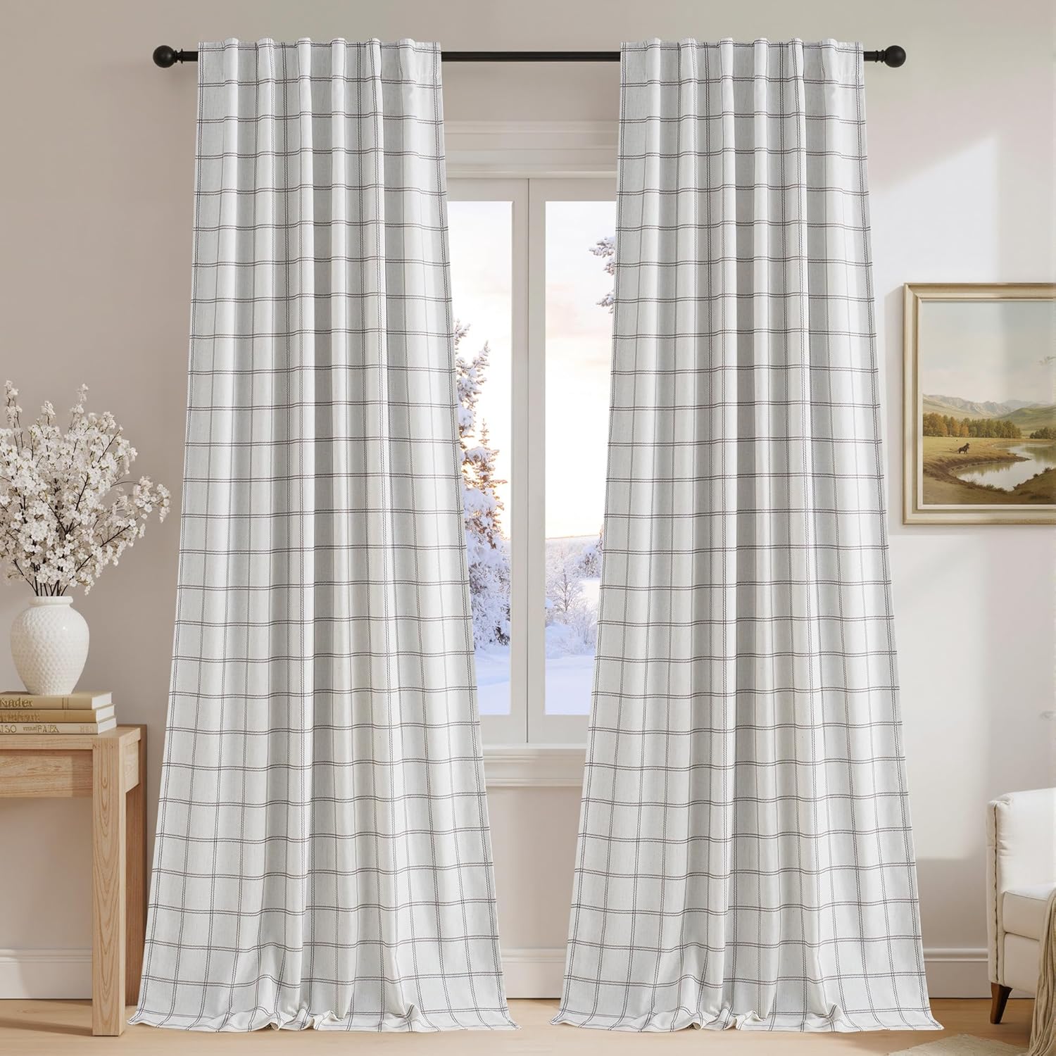 White windowpane check light filtering curtains with back tabs, hung on a black rod in a bright room.